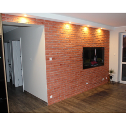 Cegła gipsowa w kolorze powiew gotyku wypalony. Widok ułożonej cegły w salonie telewizyjnym