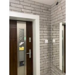 Płytki ozdobne ułożone na ścianie w przedpokoju. kompozycja kolorów szarości