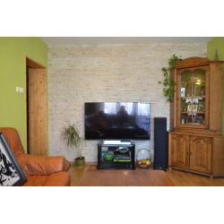 Płytki gipsowe beżowe z dodatkiem, ułożone na ścianie w pokoju dziennym