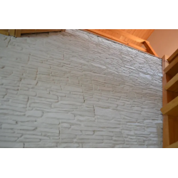 Białe kamienie ozdobne ułożone na ścianie w holu.