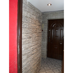 Płytki a gipsu w kolorze szarym. Przykład ułożenia w przedpokoju w bloku mieszkalnym.