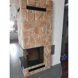 Kamienie dekoracyjne w kolorze piaskowca ułożone na kominku.