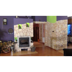 Kamień dekoracyjny ozdobny, kolor łagodny piaskowiec. Pokój dzienny z kominkiem w domu mieszkalnym.