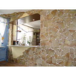 Kamień ozdobny. Widok ściany z kuchnią w tle.