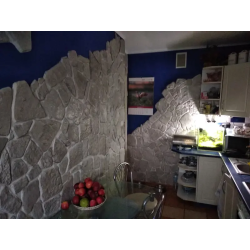 Kamień dekoracyjny szary naturalny w kuchni. Ściany częściowo ułożone.