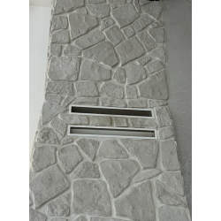 Kamień gipsowy szary ułożony na okapie kominka.